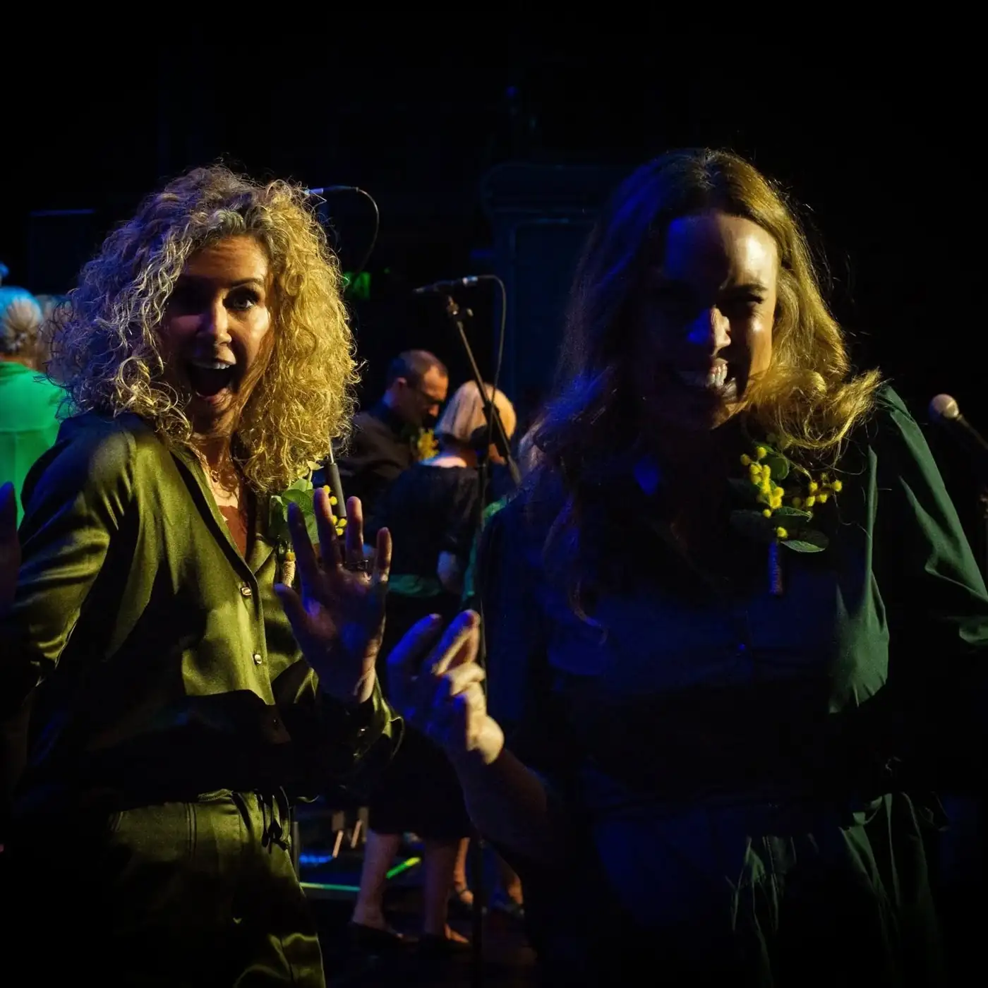 Two Sing!OZ members waving on stage