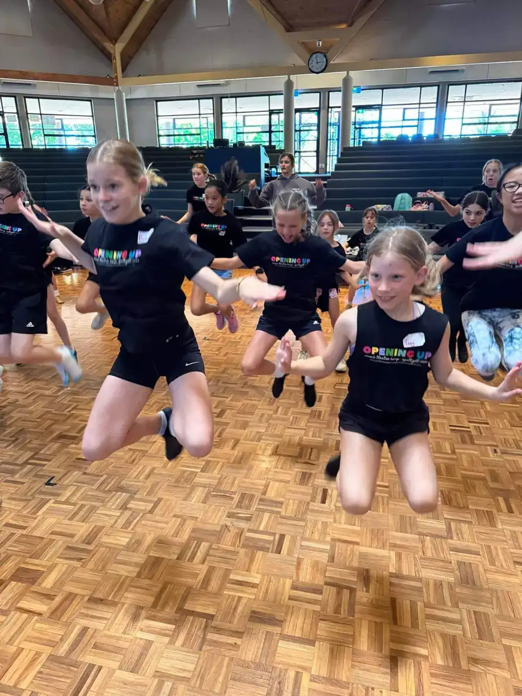 Campers leaping together during a dance rehearsal